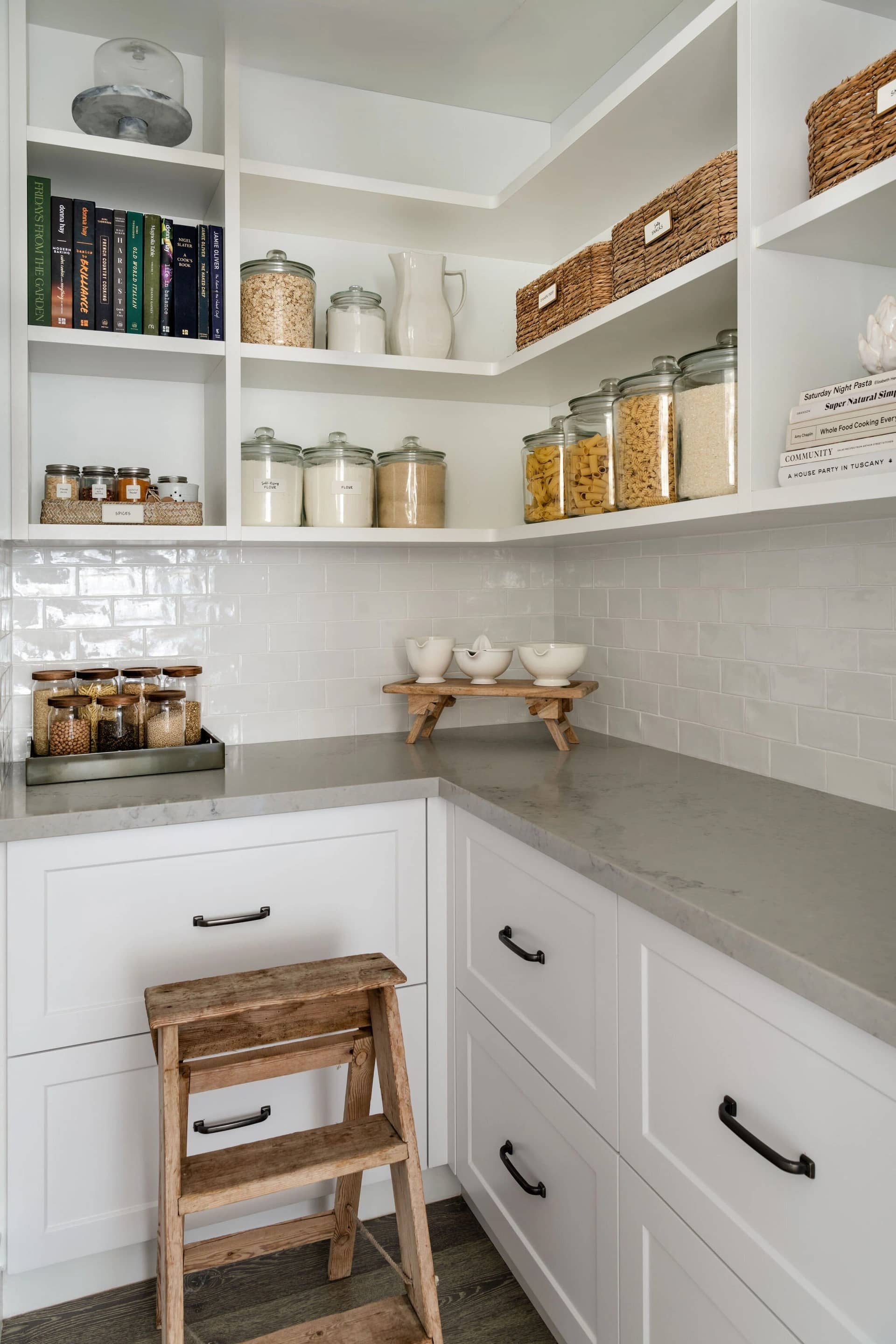 A walk-in pantry with labelled jars, baskets and a timber step stool
