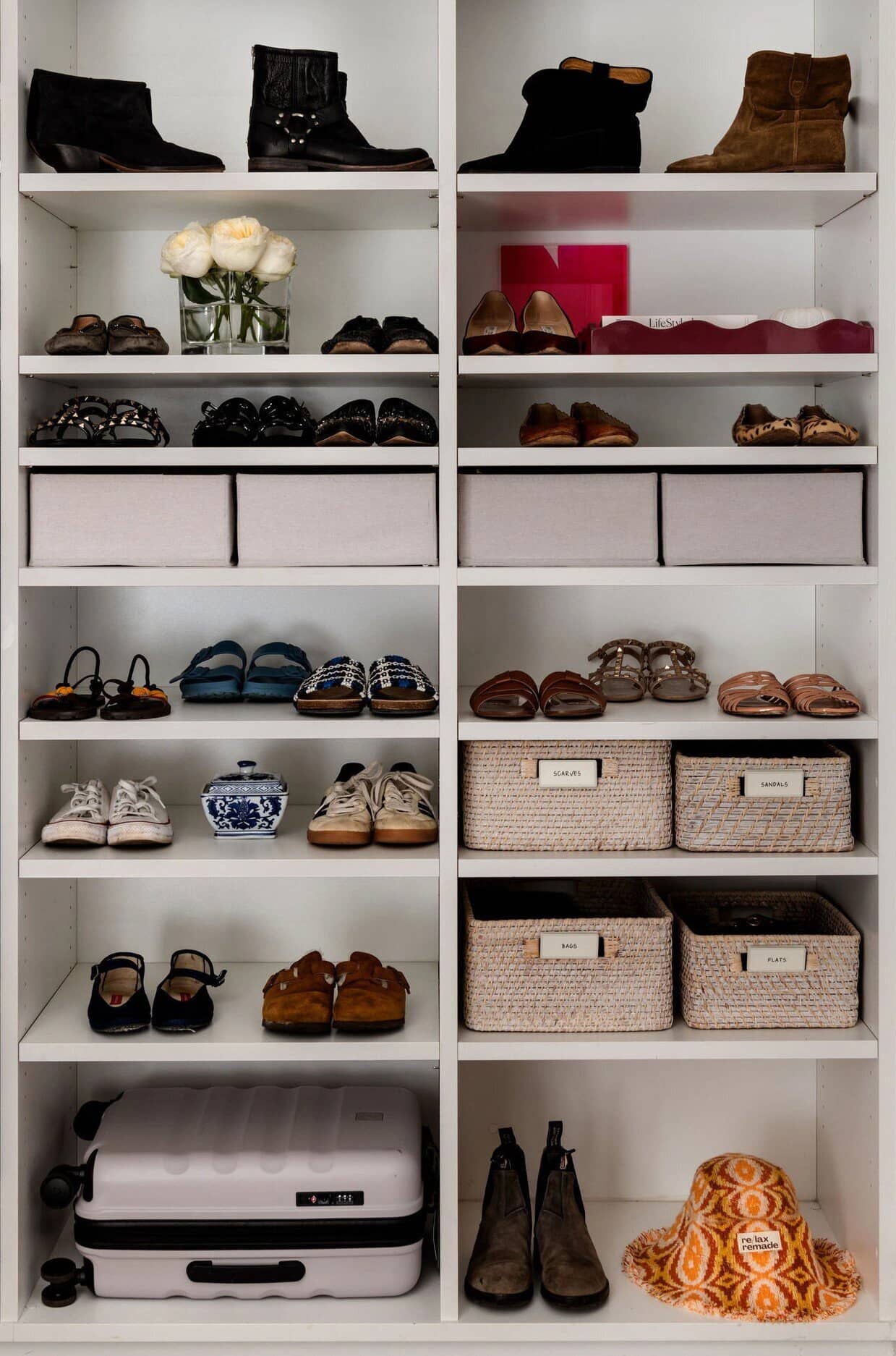 Shoes and labelled boxes in neat rows on white shelving